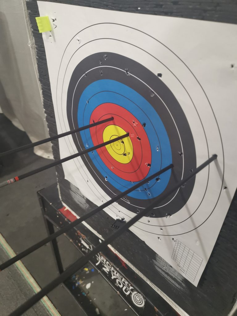 Another image of an archery target with arrows stuck in it.